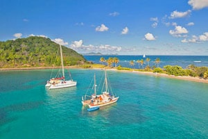 sailboats moored by an island