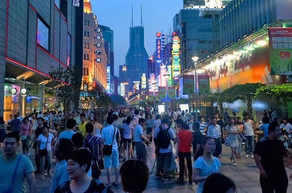 people walking on a crowded shopping street, one of the best things to do in Shanghai
