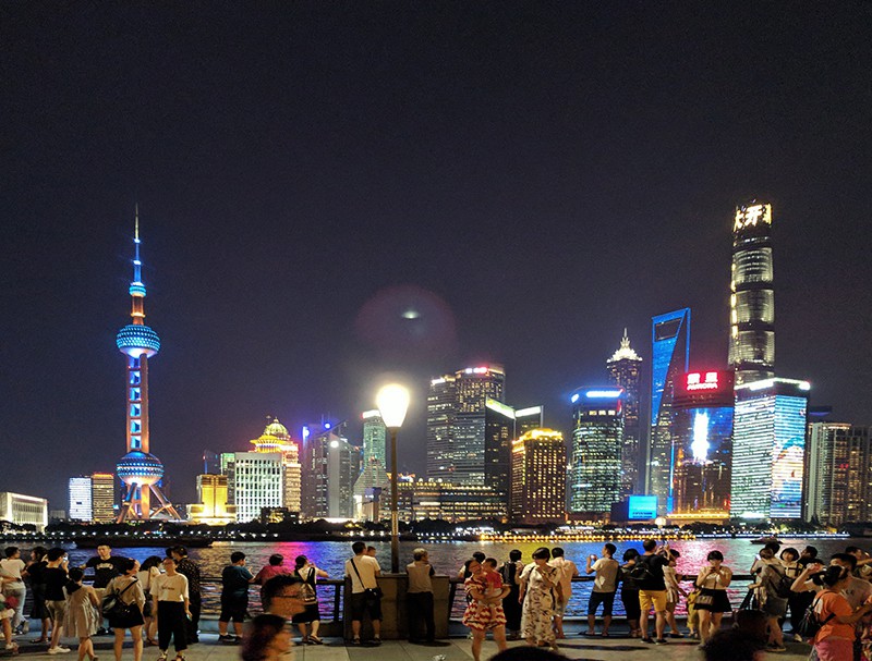 people looking at a colorful skyline, one of the best things to do in Shanghai