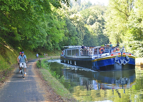 people bicycling along a canal