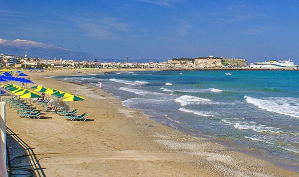 yellow umbrellas on a beach in Crete, one of the most popular Greek islands for families