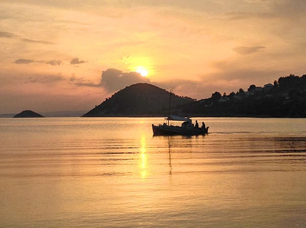 fishermen in a boat at sunset