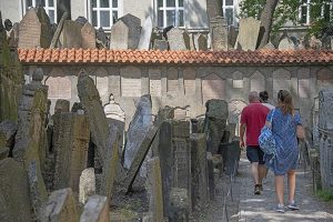 people walking through an old cemetery in Prague