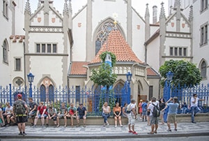 people outside a synagogue with a map of prague