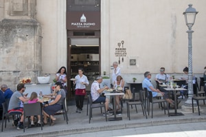 people in a cafe - cities in sicily