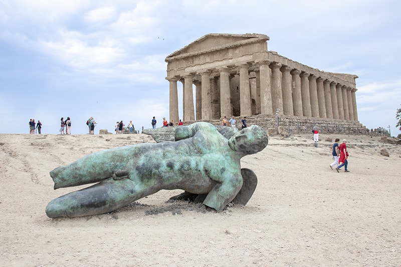 a large scultpure in front of a temple seen on a driving tour of Sicily