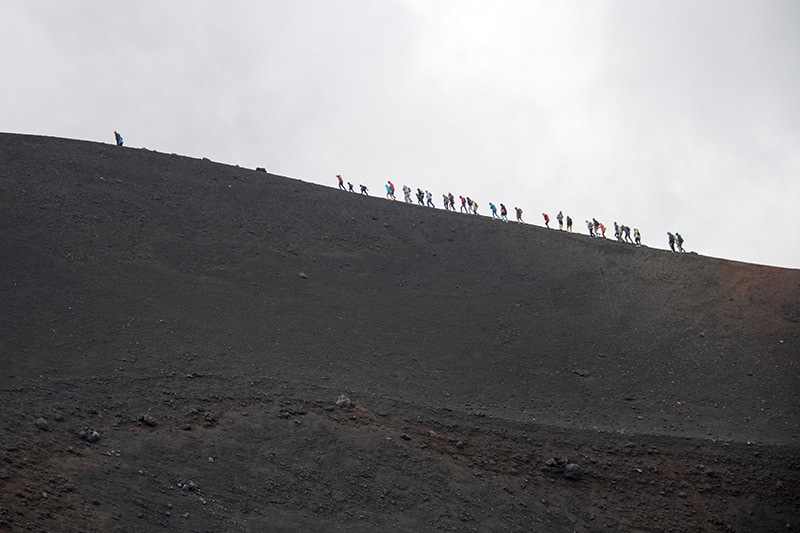 people walking along the rim of a volcano - palermo