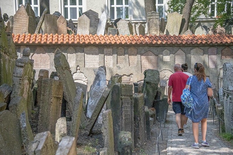 people walking through an old cemetary on a walking tour of Prague