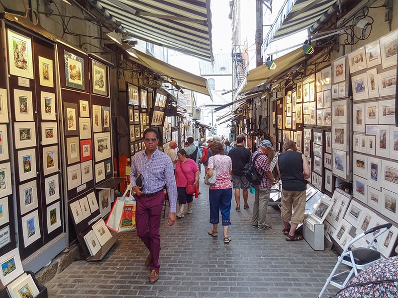 people on a street with paintings on the walls
