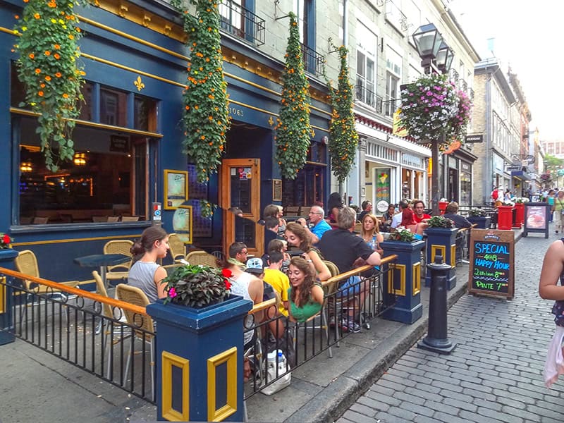 people in a colorful outdoor restaurant seen on a tour of Quebec City