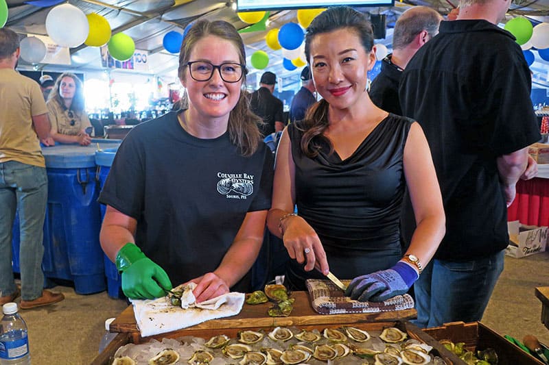 two young women shucking oysters in a restaurant well-known for its Prince Edward Island food