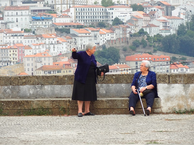 image of two women talking outside a church in Coimbra, Portugal