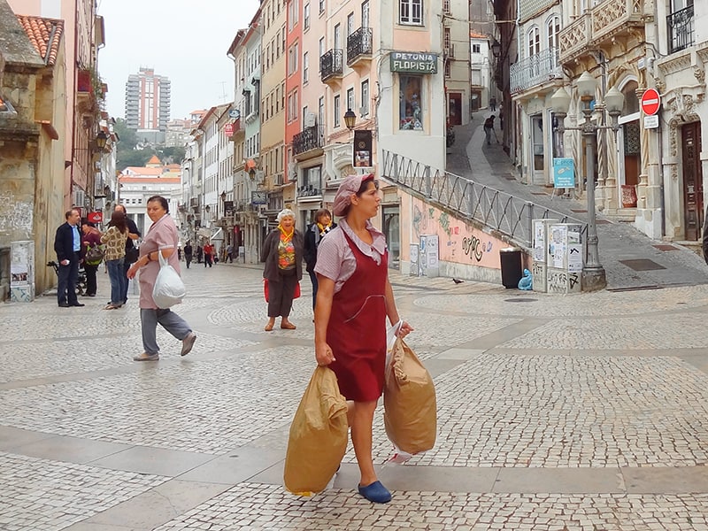 a woman walking on a street near the University of Coimbra seen on a day trip from Lisbon