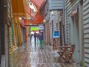 an alleyway with wooden planks - things to do in Bergen Norway