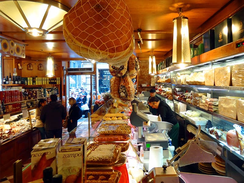 people in a shop selling Bologna food