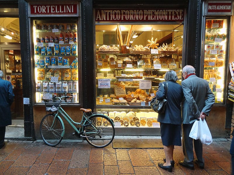 a couple looking at a window display of Bologna food