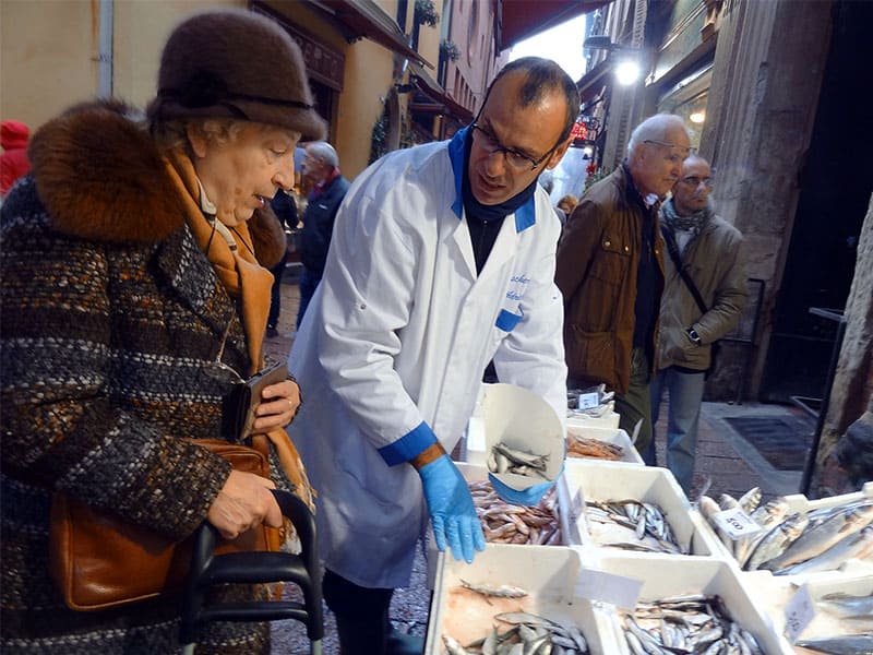 a woman talking with a fishmonger