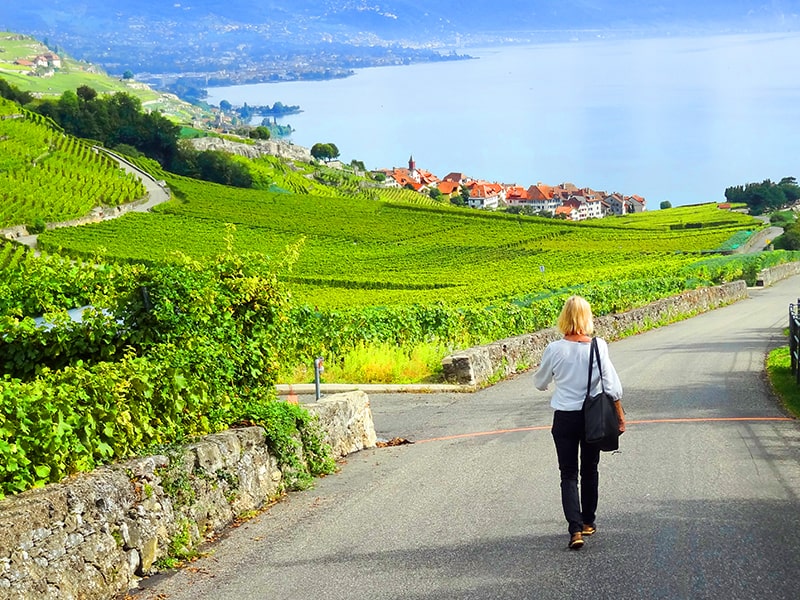 a woman walking through the Lavaux Vineyard terraces