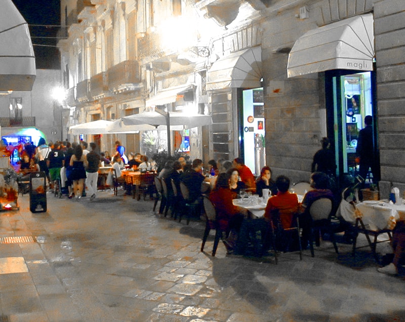 people at outdoor restaurants in Puglia, Italy