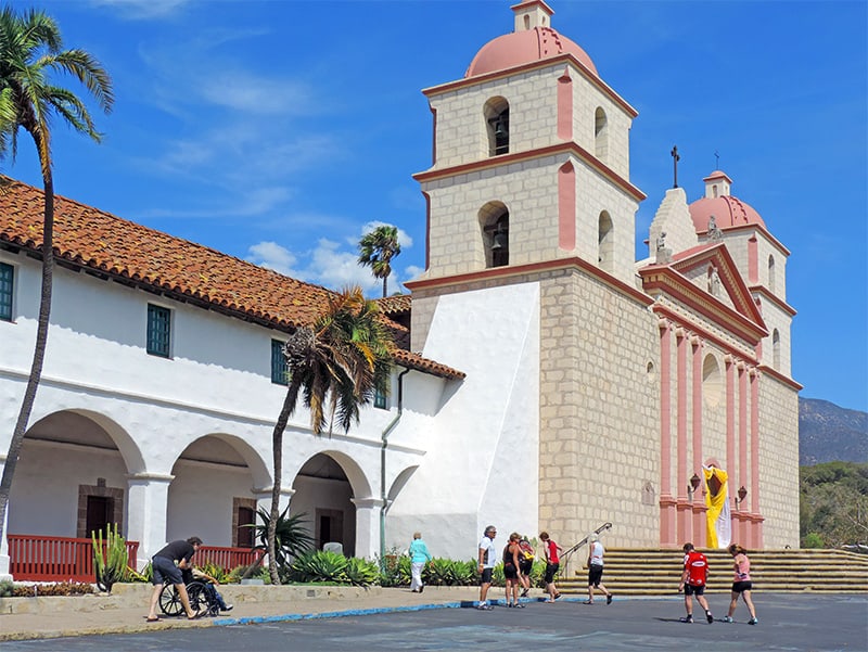 people walking by an old Spanish mission