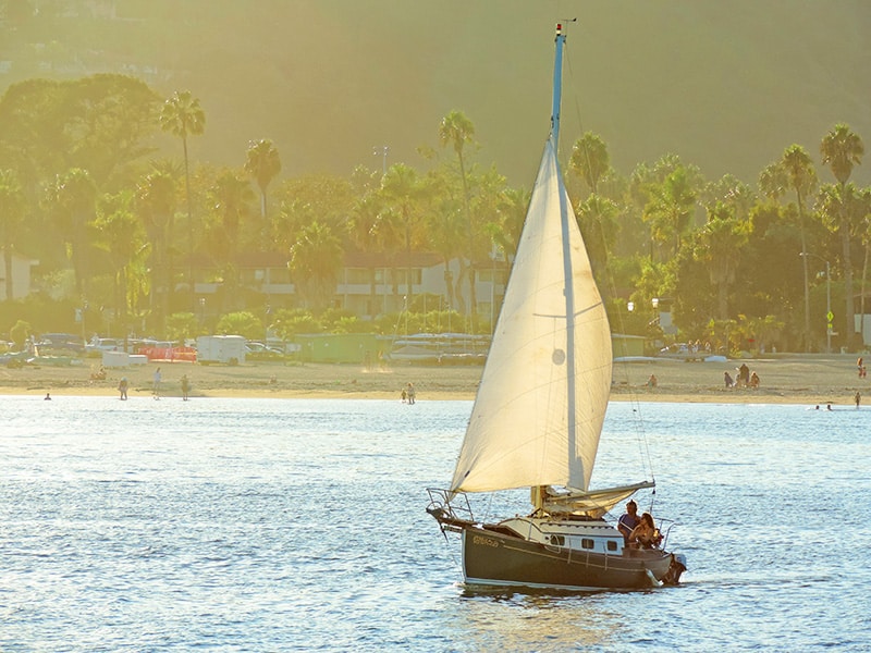 a couple sailing across the harbor of the American Riviera