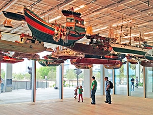 people in a museum with boats hanging from the ceiling - where to stay in Miami