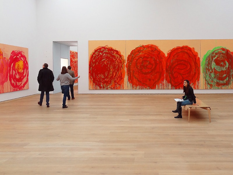 a woman sitting in a glallery in a modern art museum