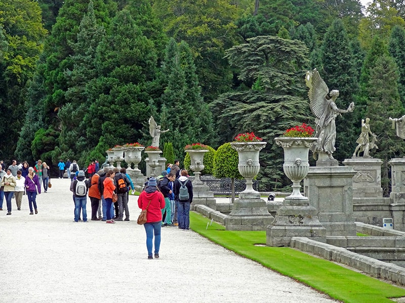 visitors walking by statuary on a lawn at Powerscourt, seen on day trips from Dublin
