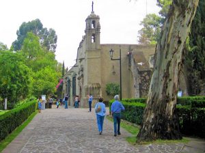 a couple walking towards a museum in a park, one of the things to do in Mexico City