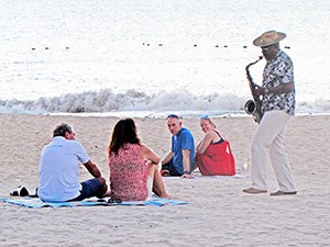 man playing a saxophone on the beach at a luxxury St Lucia accommodation