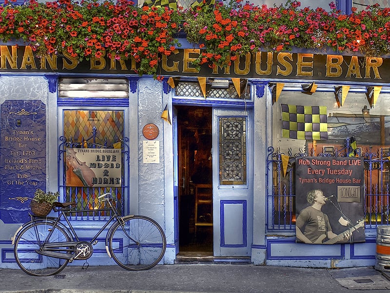 a bicycle in front of a bar painted blue in Kilkenny