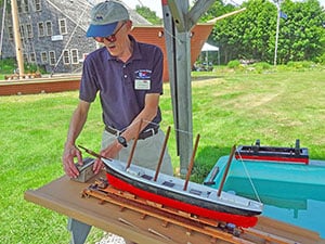 a museum docent with a model ship in a museum in Bath