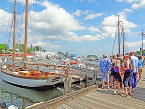 people on a dock awaiting a schooner in Camden, one of the popular towns on Maine Route 1