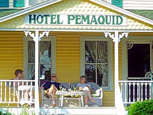 people enjoying coctails on the porch of a hotel on the Maine coast