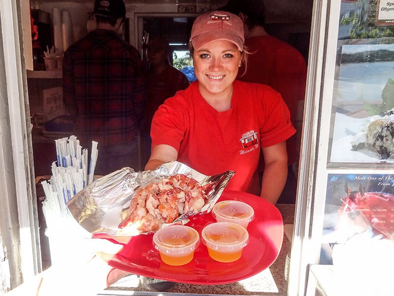 a waitress handing a customer a loberster roll in Wiscasset, one of the popular Maine coastal towns on Maine's Route 1