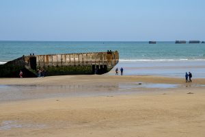 Remnants of the Mulberry Harbors on the beach and in the sea at Arromanches-les-Bains