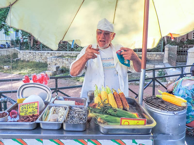 a street vendor pointing at the camera