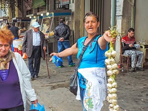 a woman holding a rope of garlic