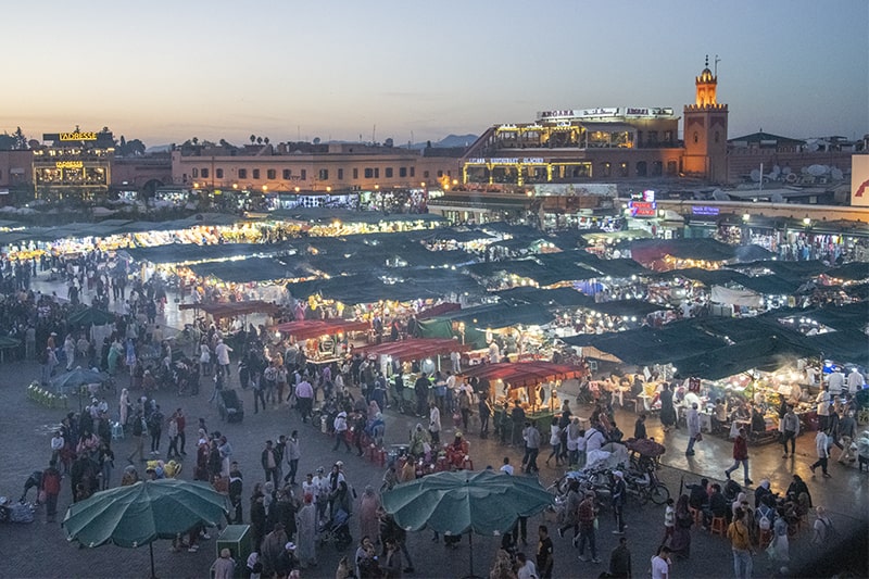 crowds of people in a large public square in Marrakesh, one of the places to visit in Morocco
