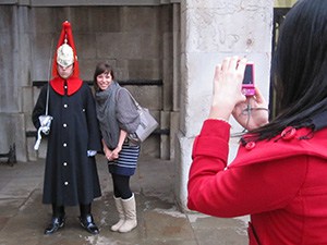 tourists taking photo of soldier at attention