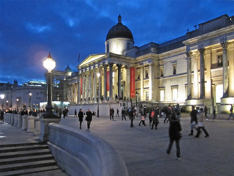 people on an evening walk in London passing a museum