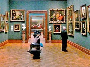 people in a musem looking at paintings