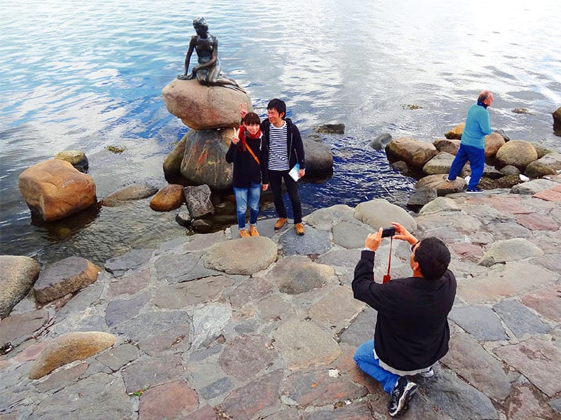 people by the Little Mermaid taking photos