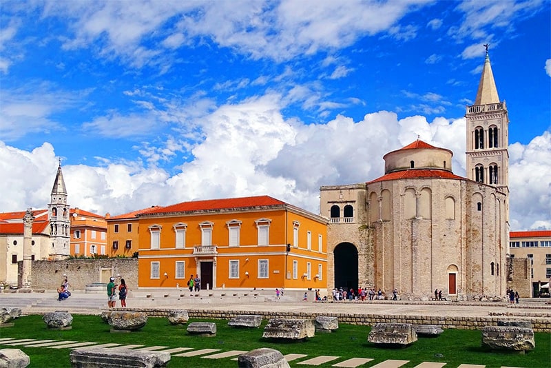 a church and a yellow building in one of the best cities in Croatia