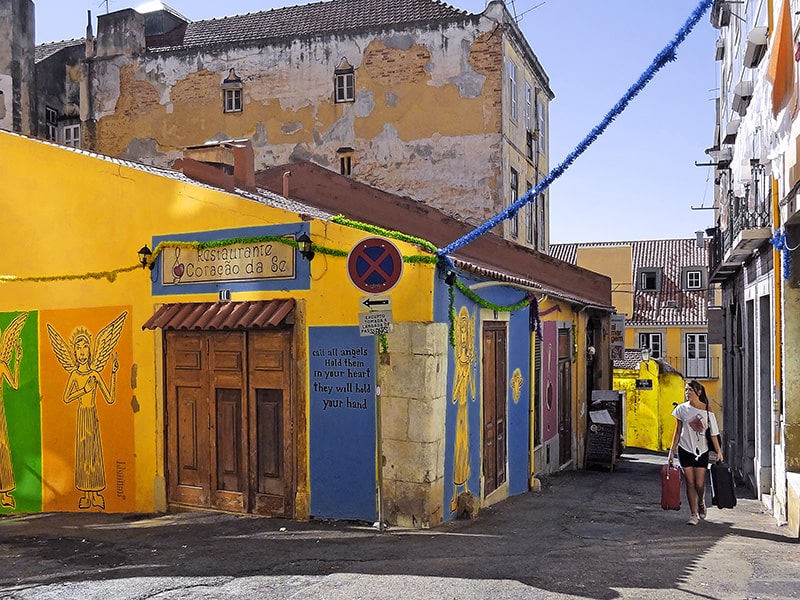 a woman walking along the old streets of Alfama, one of the things to do in Lisbon