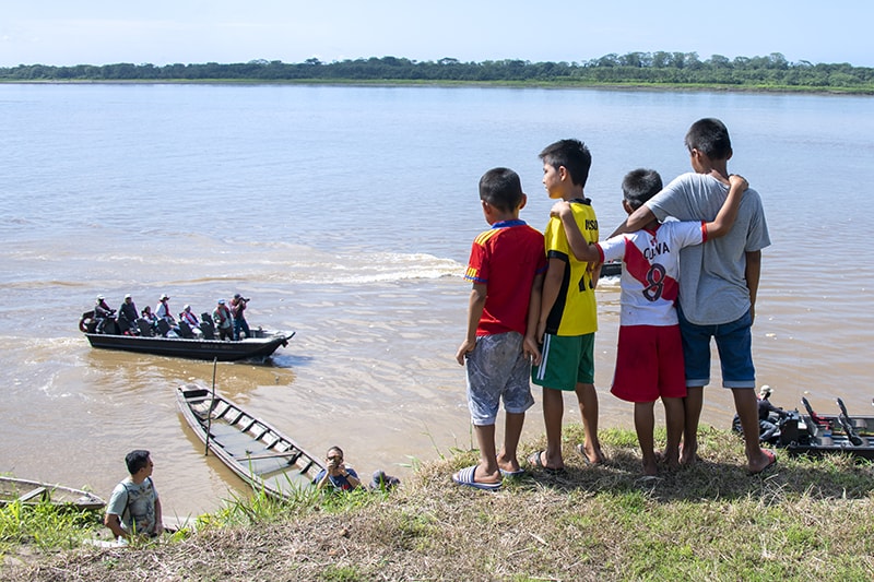 boys looking down from a high riverbank