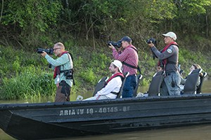 people in a skiff photographing wildlife