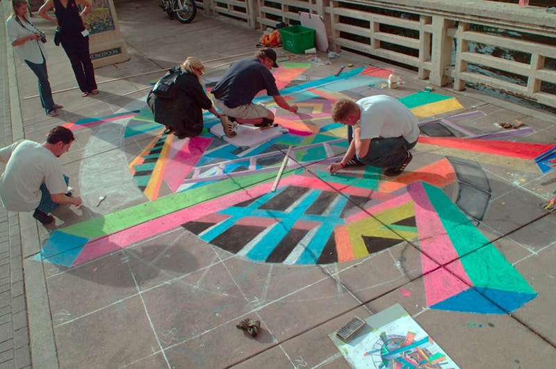 people wioth chalk on a sidewalk