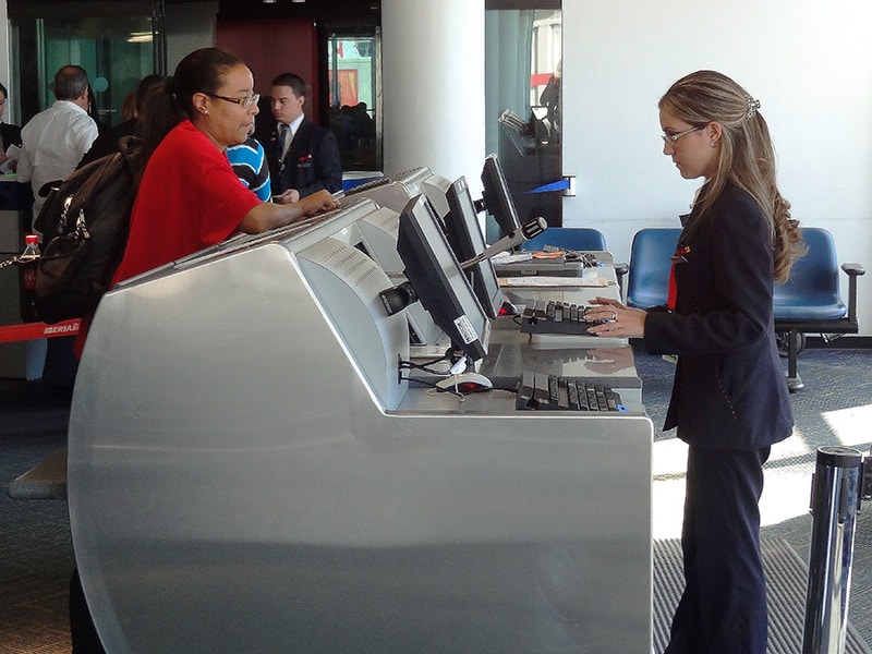 a womanr talking with an agent about an overbooked flight