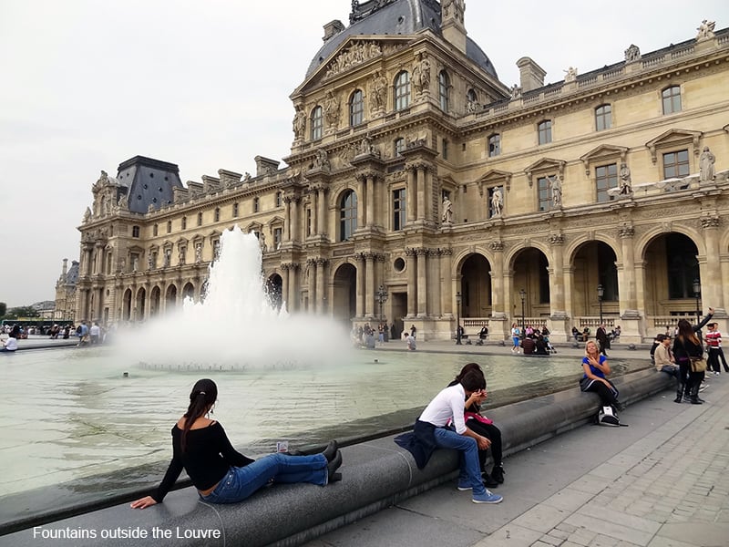people sitting by a fountain in photos of Paris